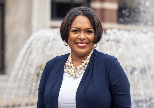 Dean Gretchen Givens Generett outside smiling with fountain and School of Education building in background.
