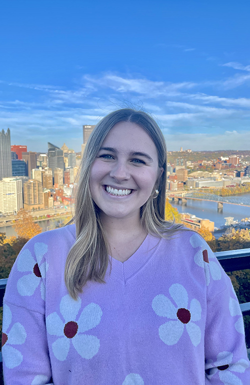 Emma LaRocco with PIttsburgh cityscape and river in background.
