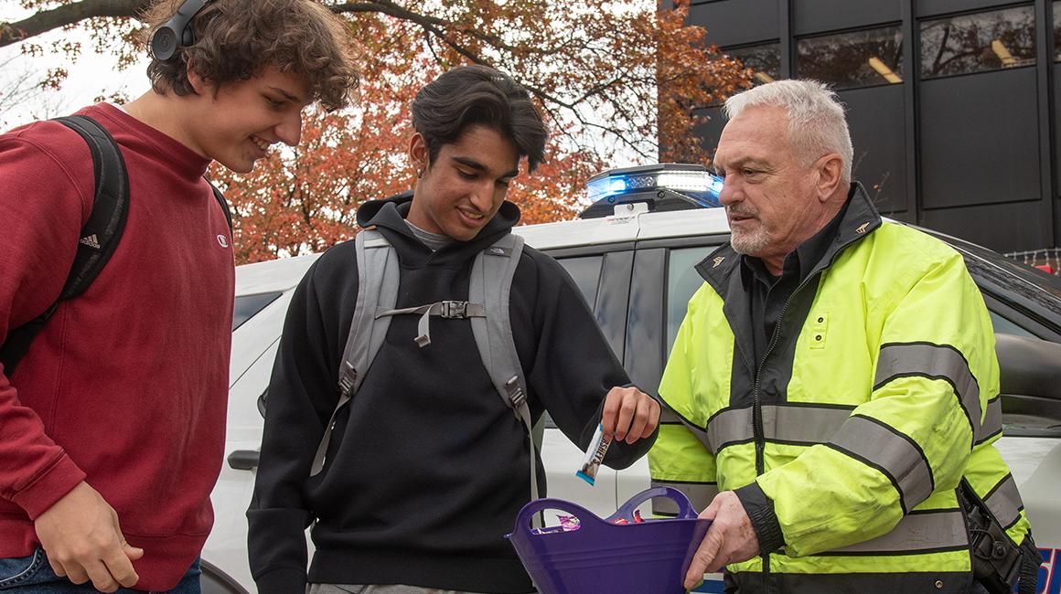 Sergeant Frank Cortazzo hands out candy to students on Halloween