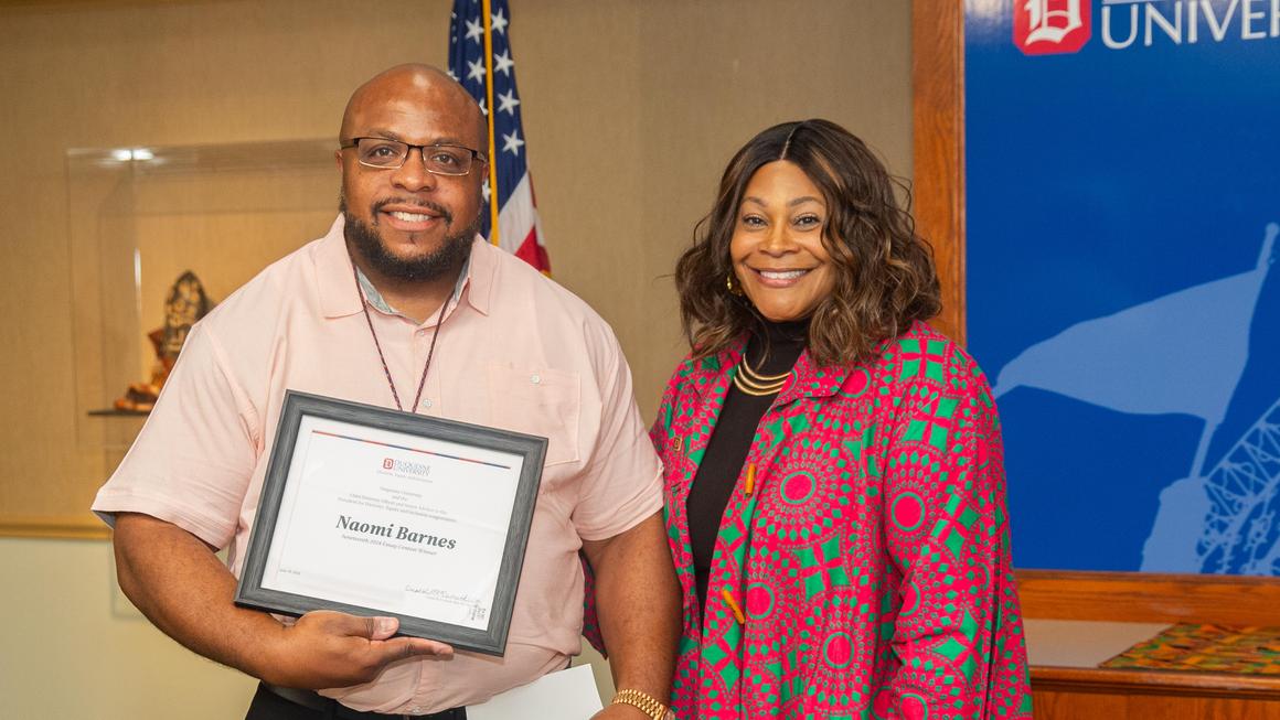 Crystal McCormick Ware presents Naomi Barnes' essay winner certificate to a representative from her school.